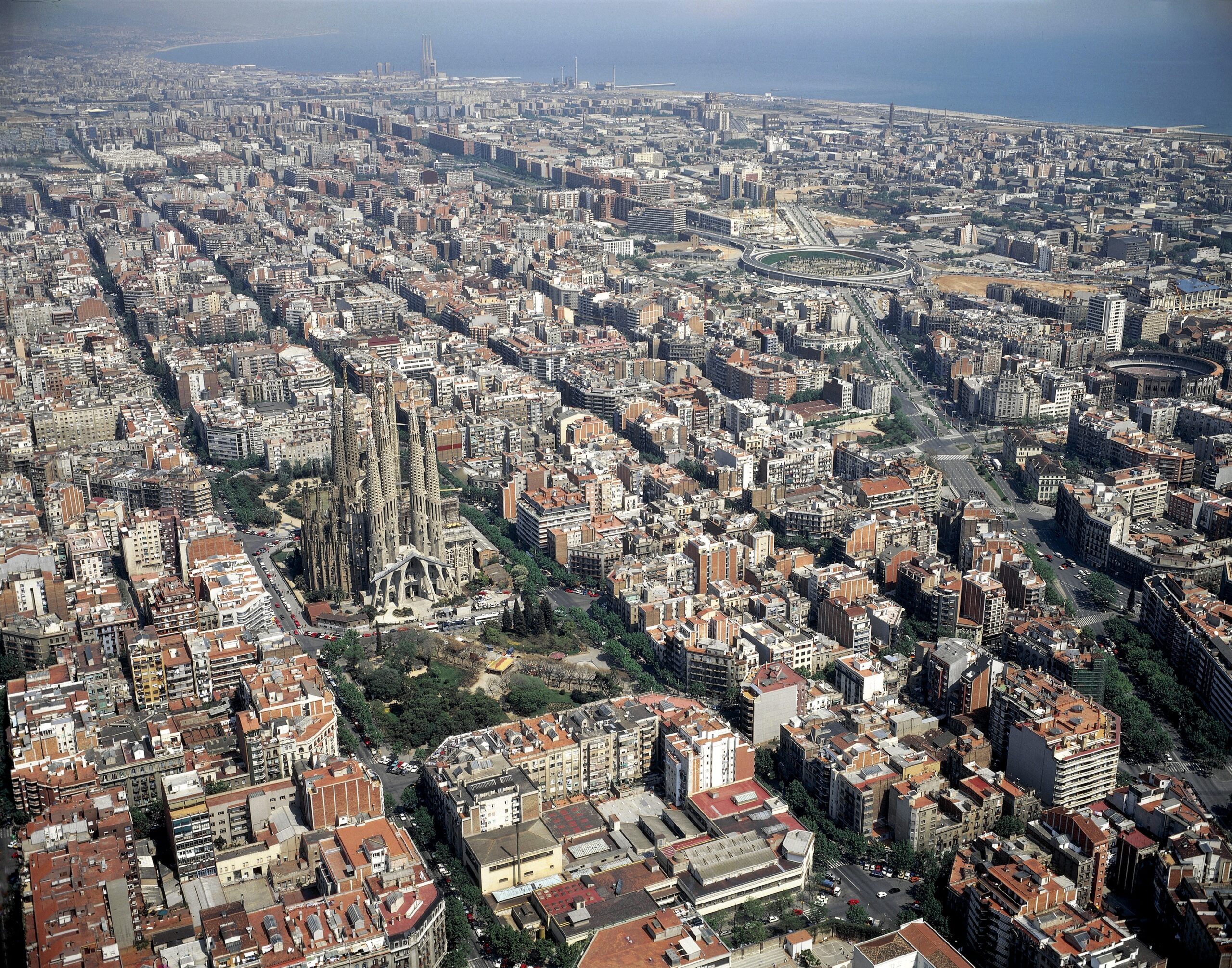 Aerial view of Barcelona from the Eixample district to the sea in the distance, with the Sagrada Familia church in the middle