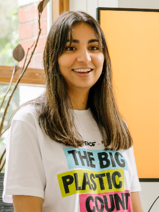 Poppy Johal wearing a t-shirt that says the big plastic count. She's smiling at something beyond the camera