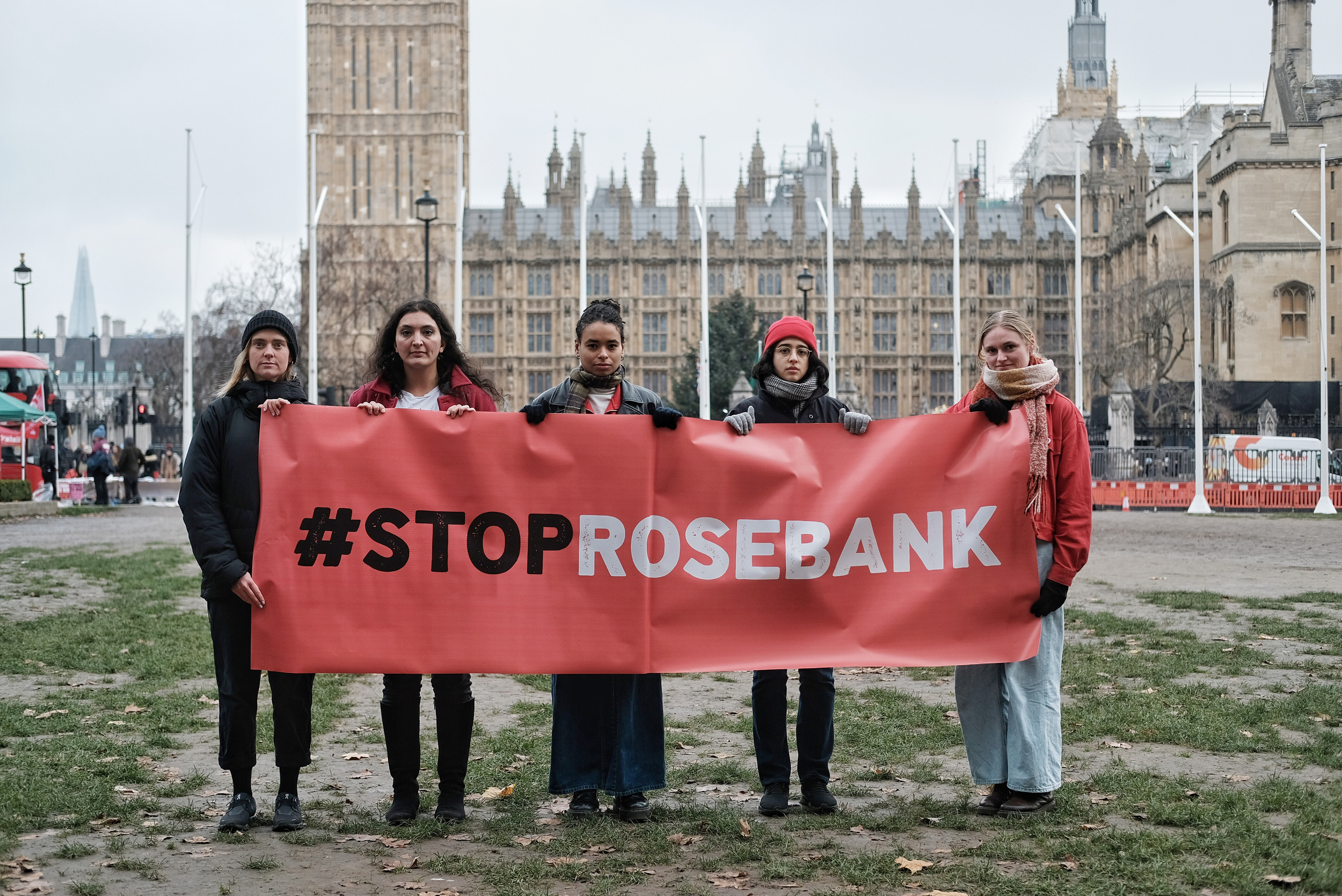 5 people stand in front of the House of Commons holding a big red banner reading #StopRosebank