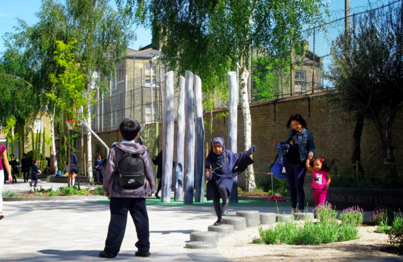 Children playing on Van Gogh Walk in London, with trees, play equipment and a basketball hoop in the background.
