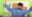 Still from a video showing a presenter gesturing in front of a diagram