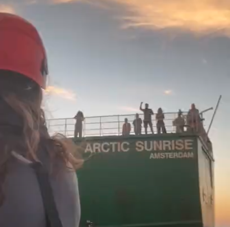 People in the deck of a ship cheering and waving to someone in a small boat