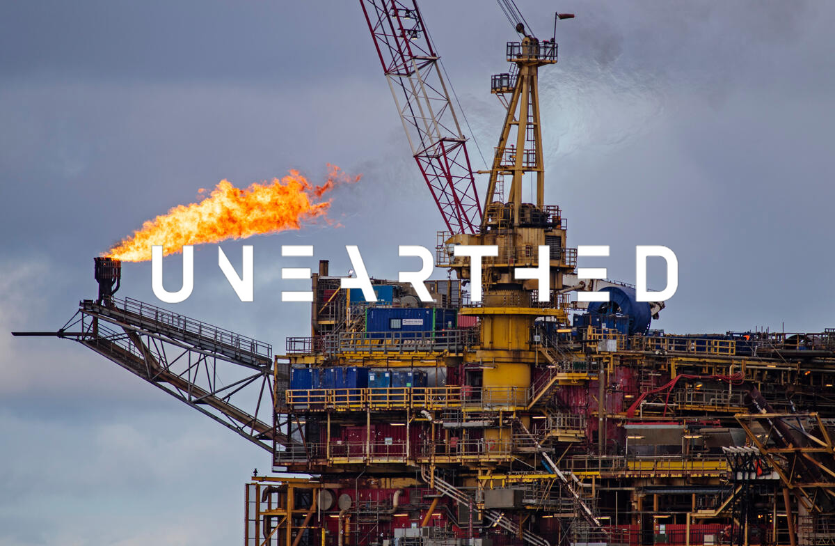 An orange flame erupts from the end of a gantry on an oil rig.
