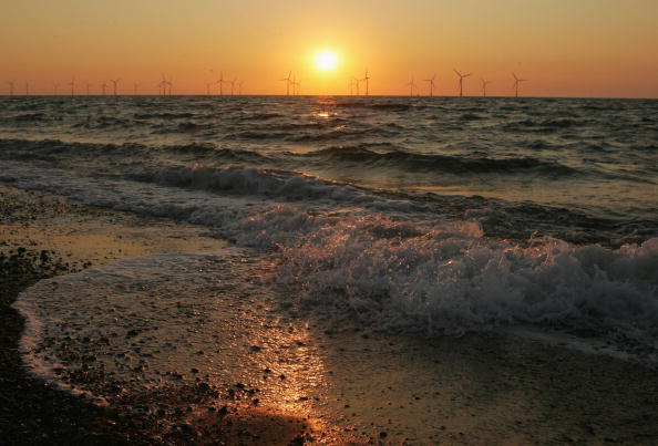 Offshore wind turbines on the horizon at sunset