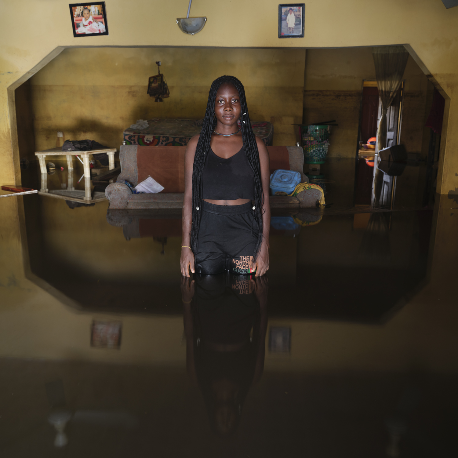 Portrait of a woman in her flooded home.