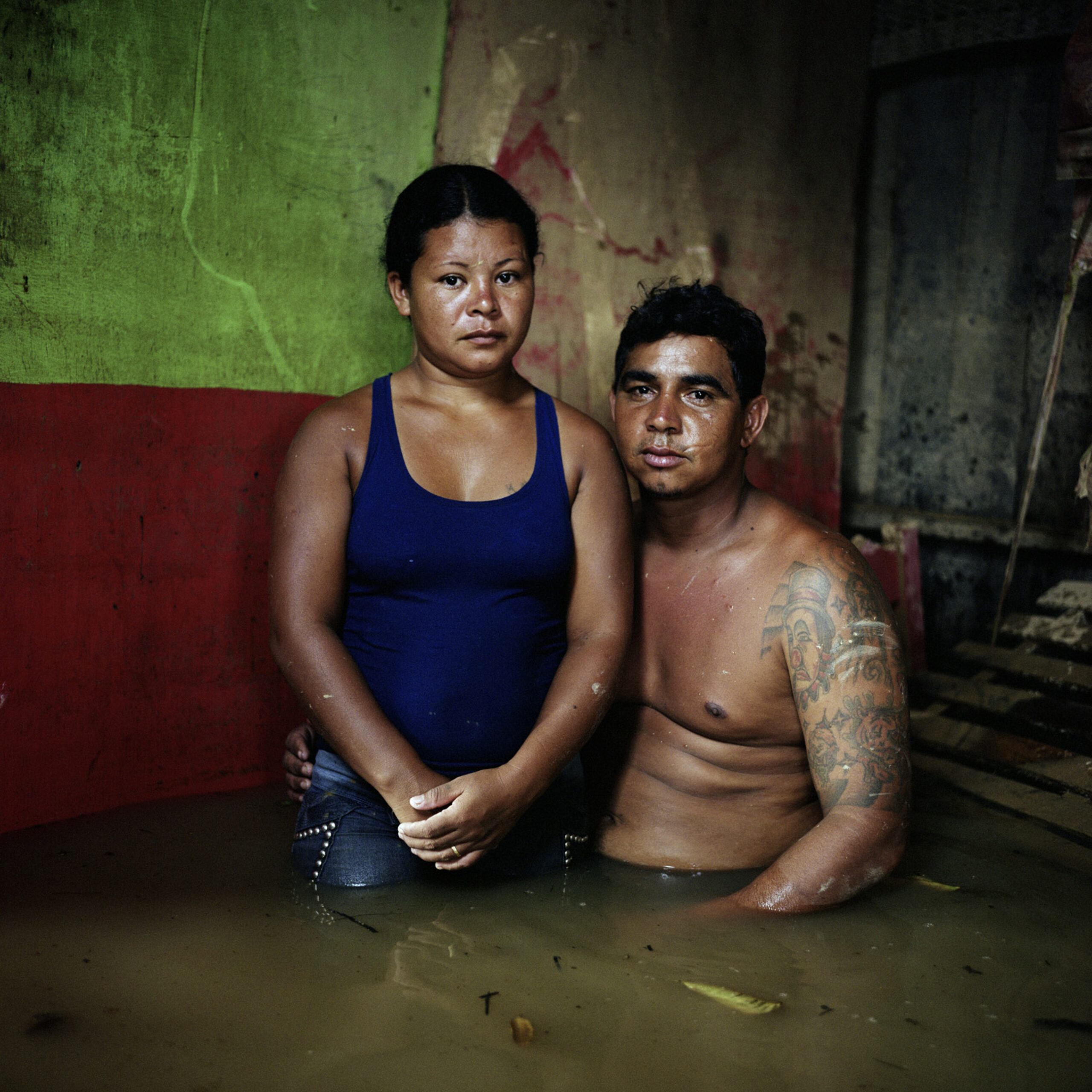 A man and a woman stand in flooding on a street corner