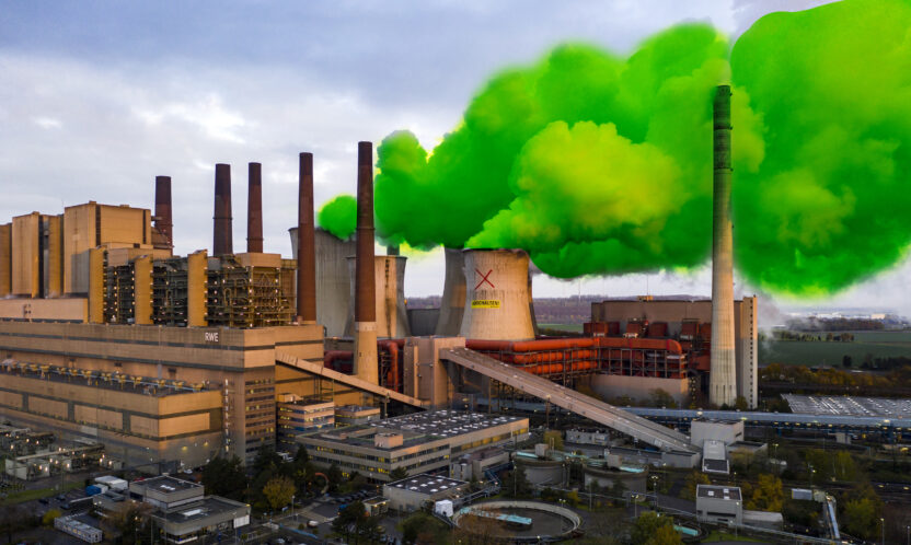 Photo illustration shows plumes of green steam coming from a power station cooling tower