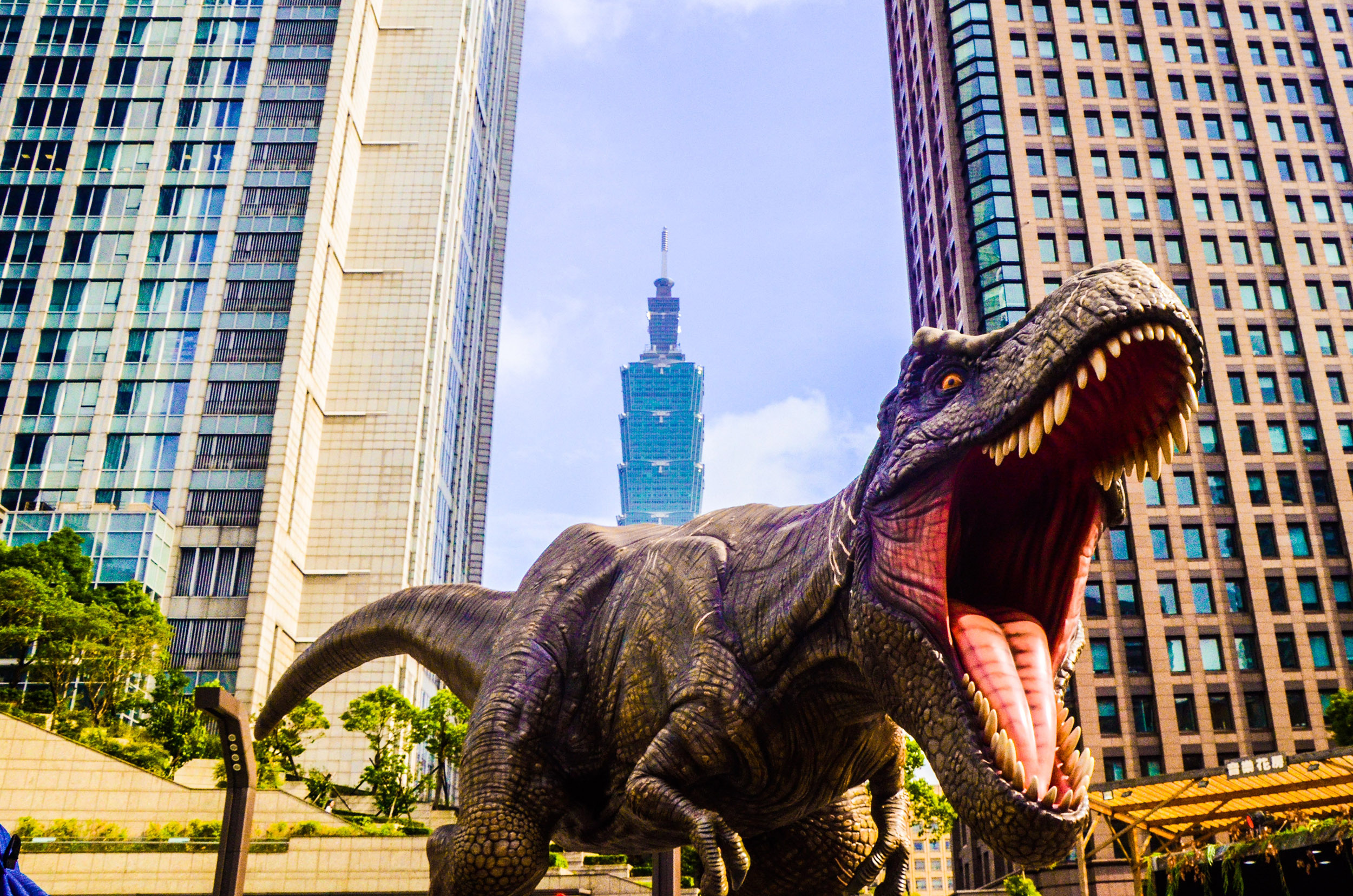 Digital illustration of a t-rex roaring with skyscrapers in the background.