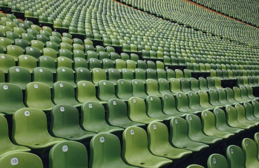 A bank of green stadium seating, all empty, used to illustrate the concept of sportswashing.