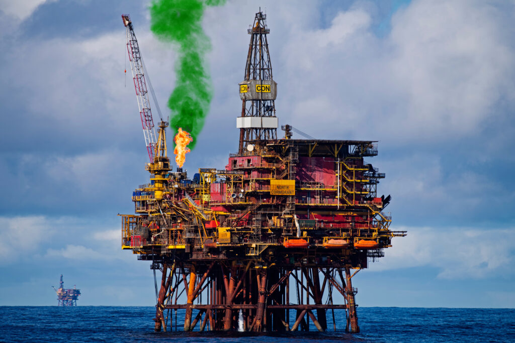 Photo illustration shows an oil rig with a plume of green smoke coming from the flaring tower.