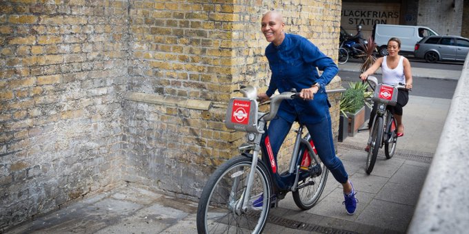 A man and a woman riding hire bikes in London