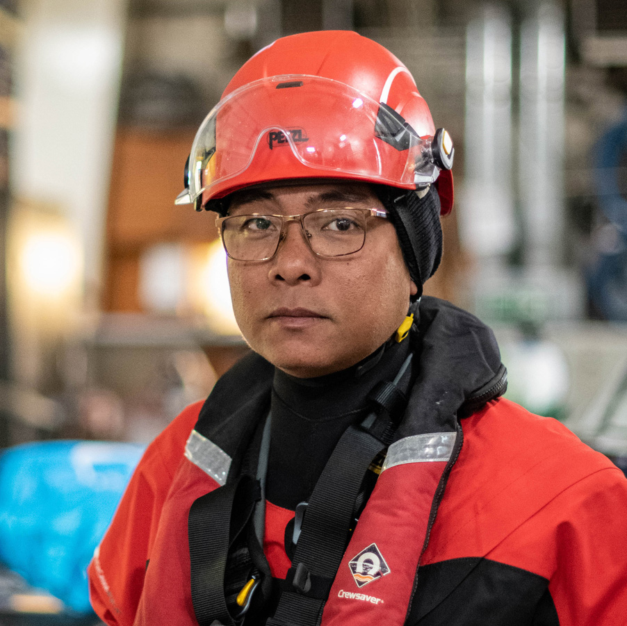 Portrait of Yeb Sano in a helmet and life jacket. He's looking into the camera with a serious expression.