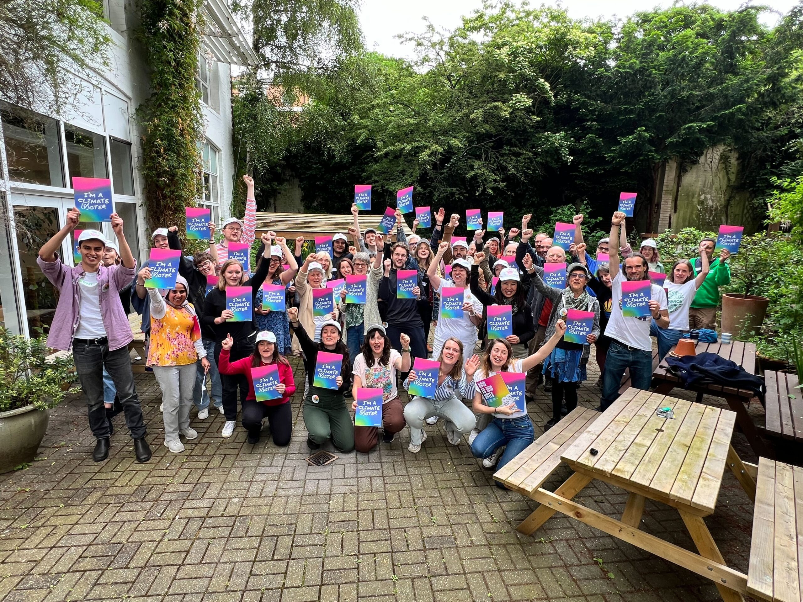 A large group of Climate vote volunteers hold up their posters