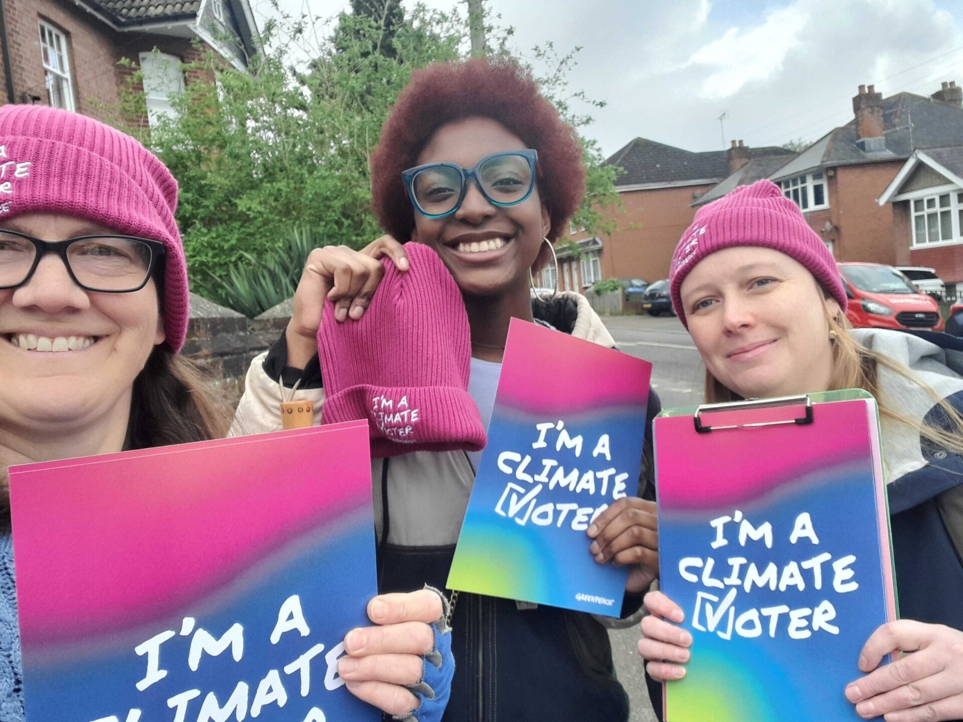 Climate vote volunteers hold up their posters