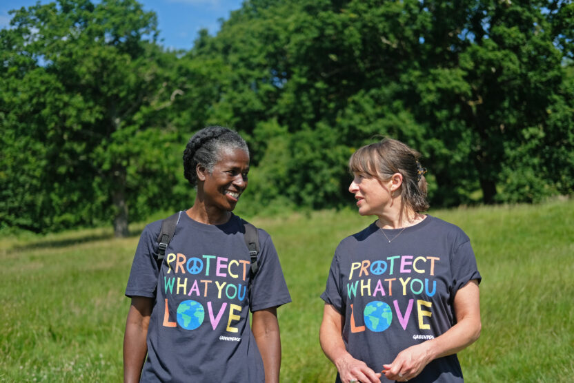Two people walking through long grass with 'protect what you love' t-shirts on