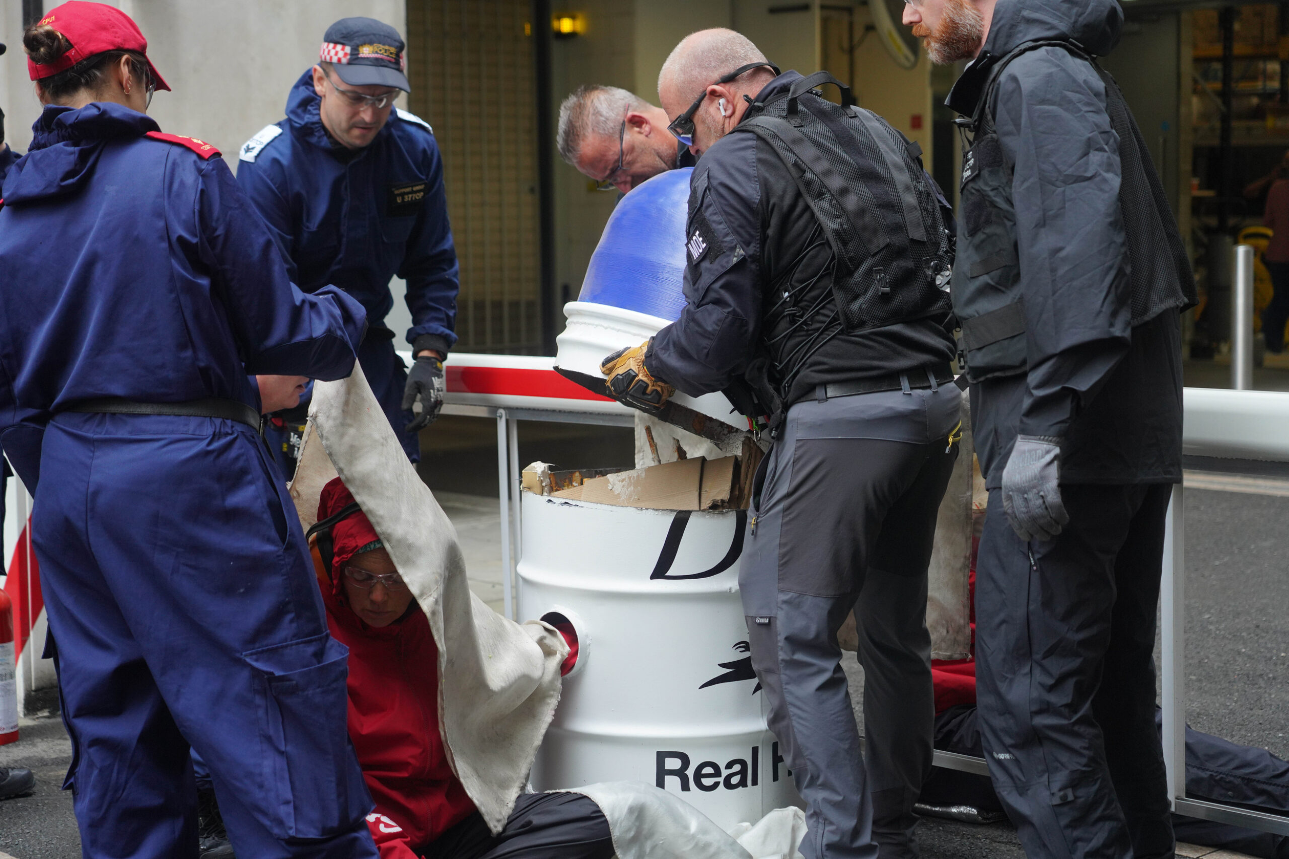 Police dismantle a large model of a Dove deodorant container.
