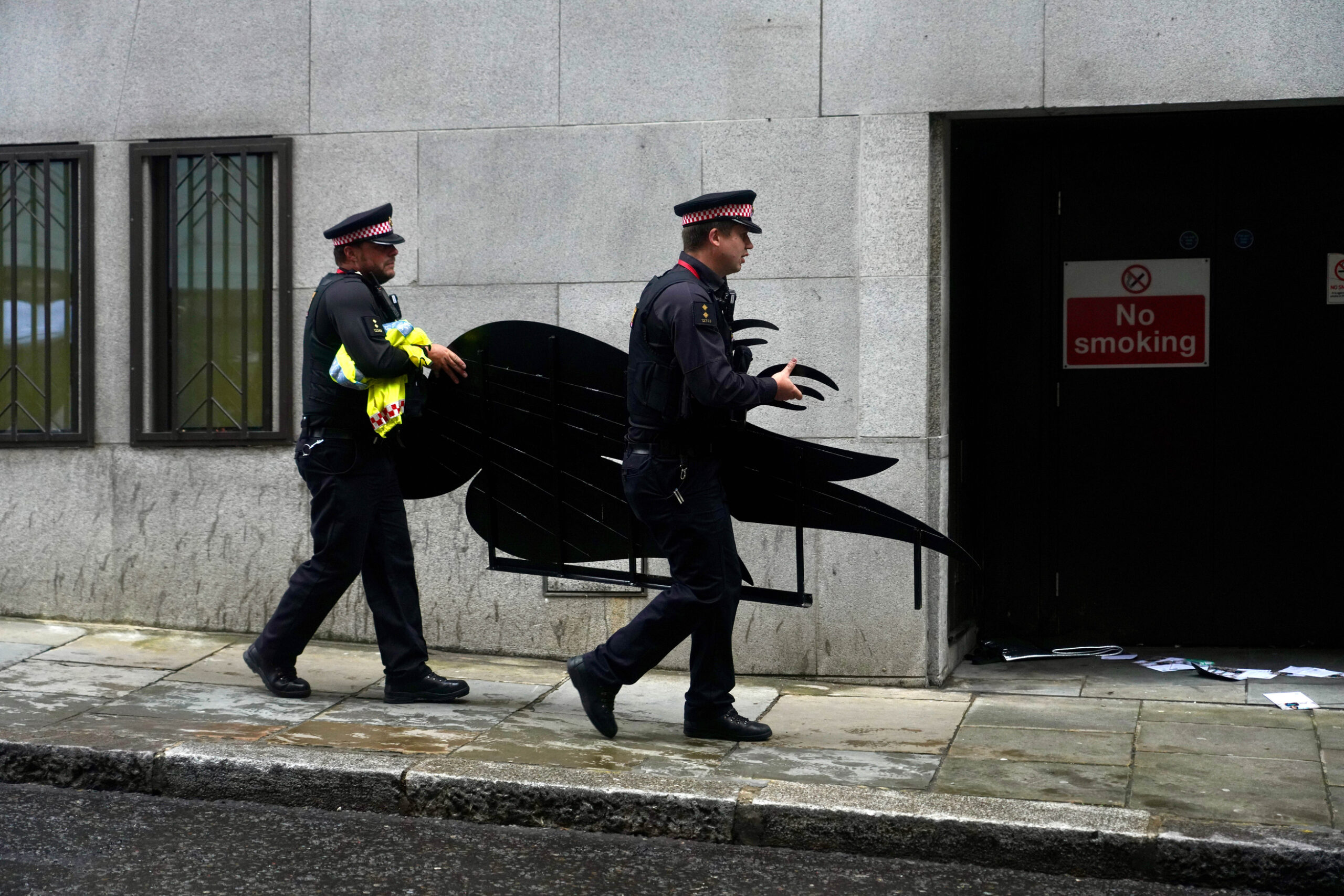 Police carry away a large model of a dead bird designed to parody to Dove logo.