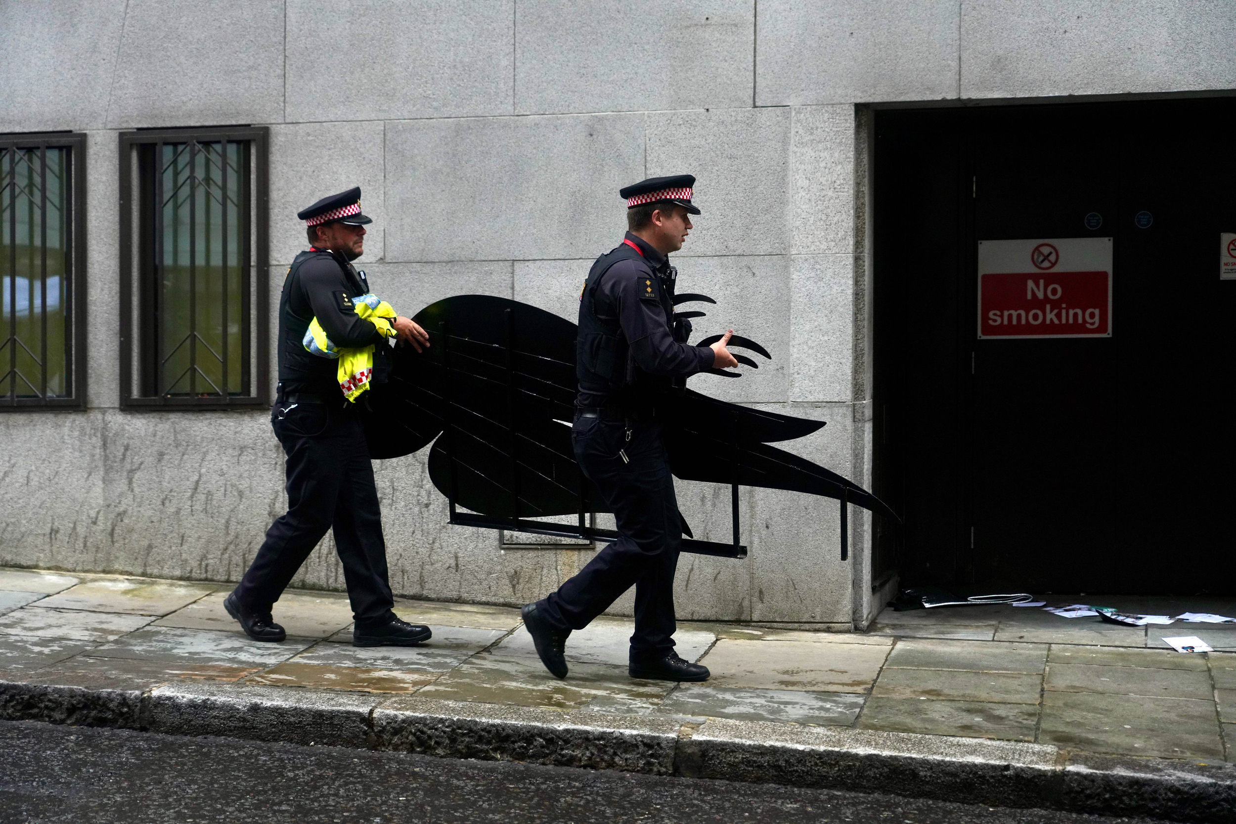 Police carry away a large model of a dead bird designed to parody to Dove logo.