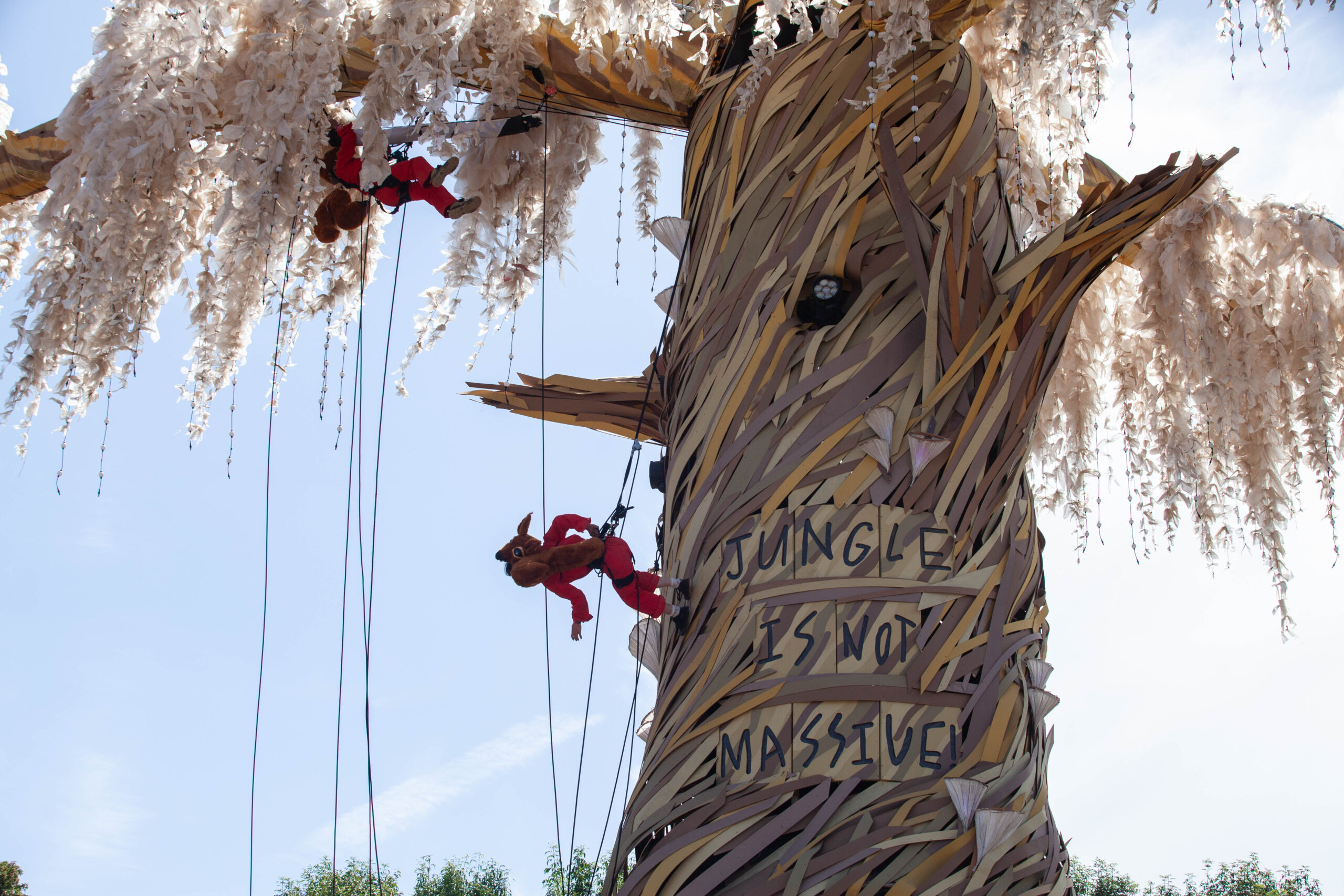 A climber abseils down a lifesize fake tree.