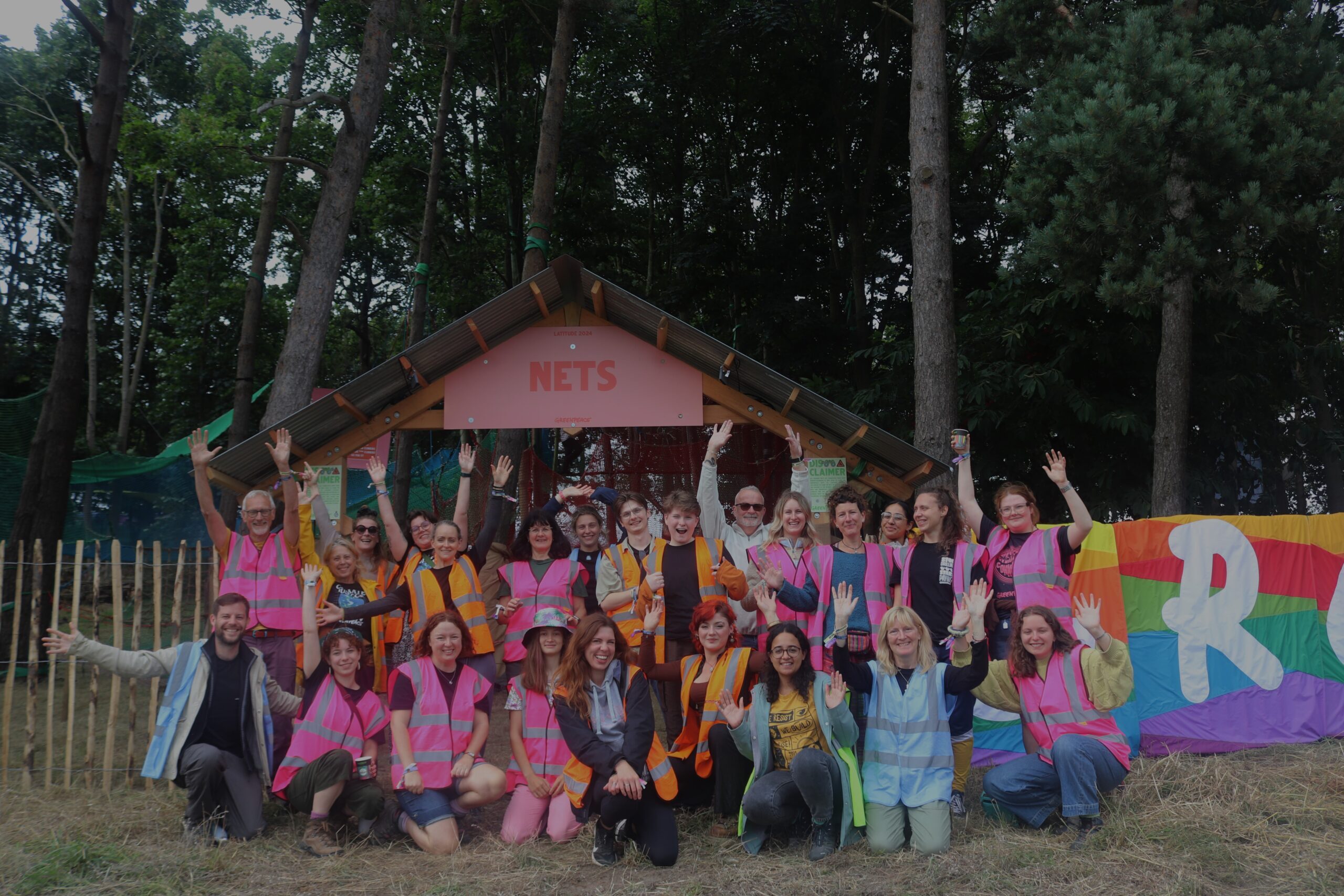 Greenpeace volunteers pose for a group photo in front of a beautiful forest.