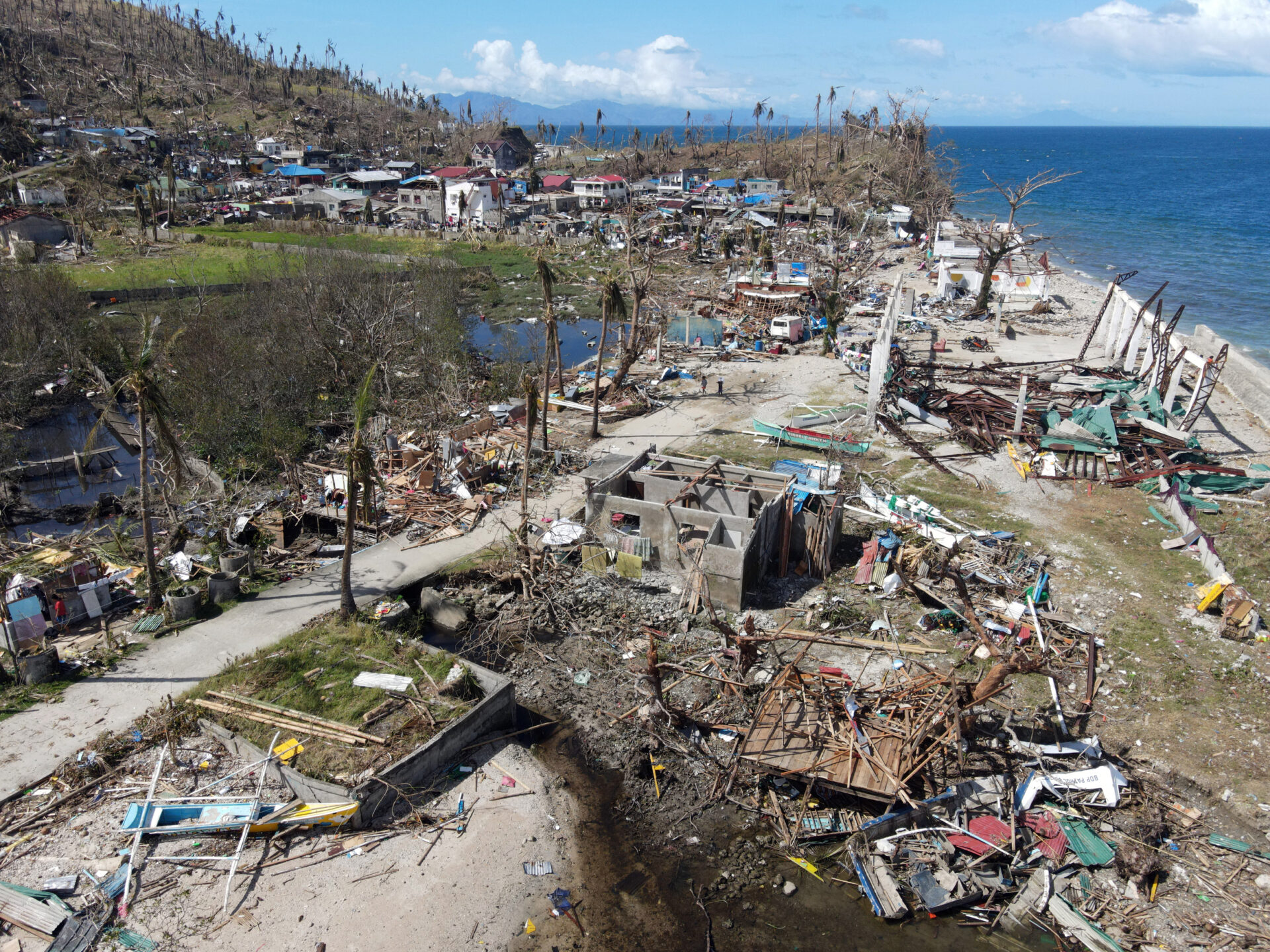 Aerial view of destruction with broken houses and destroyed palm trees