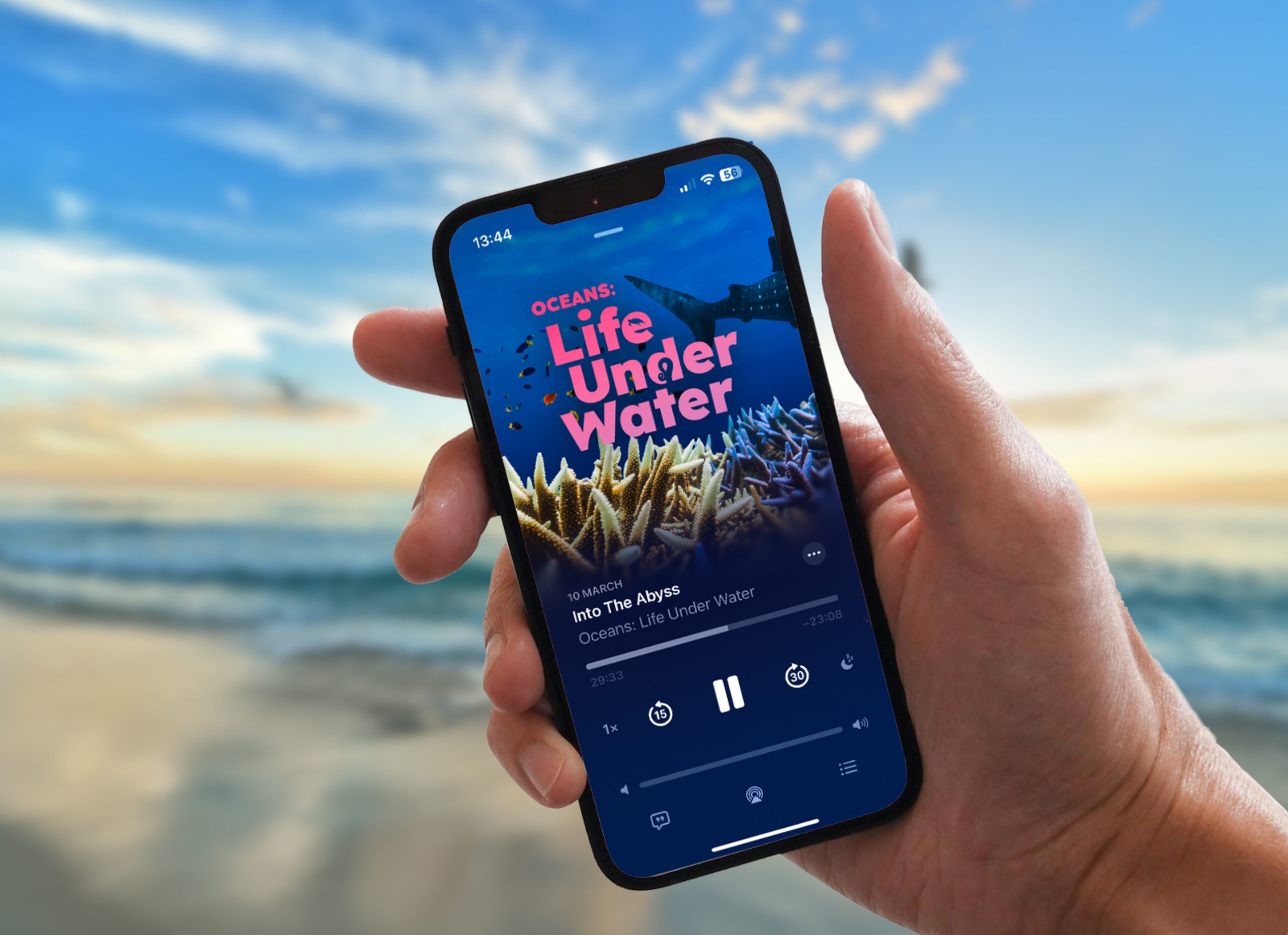 Hand holding a phone playing the Life Under Water podcast