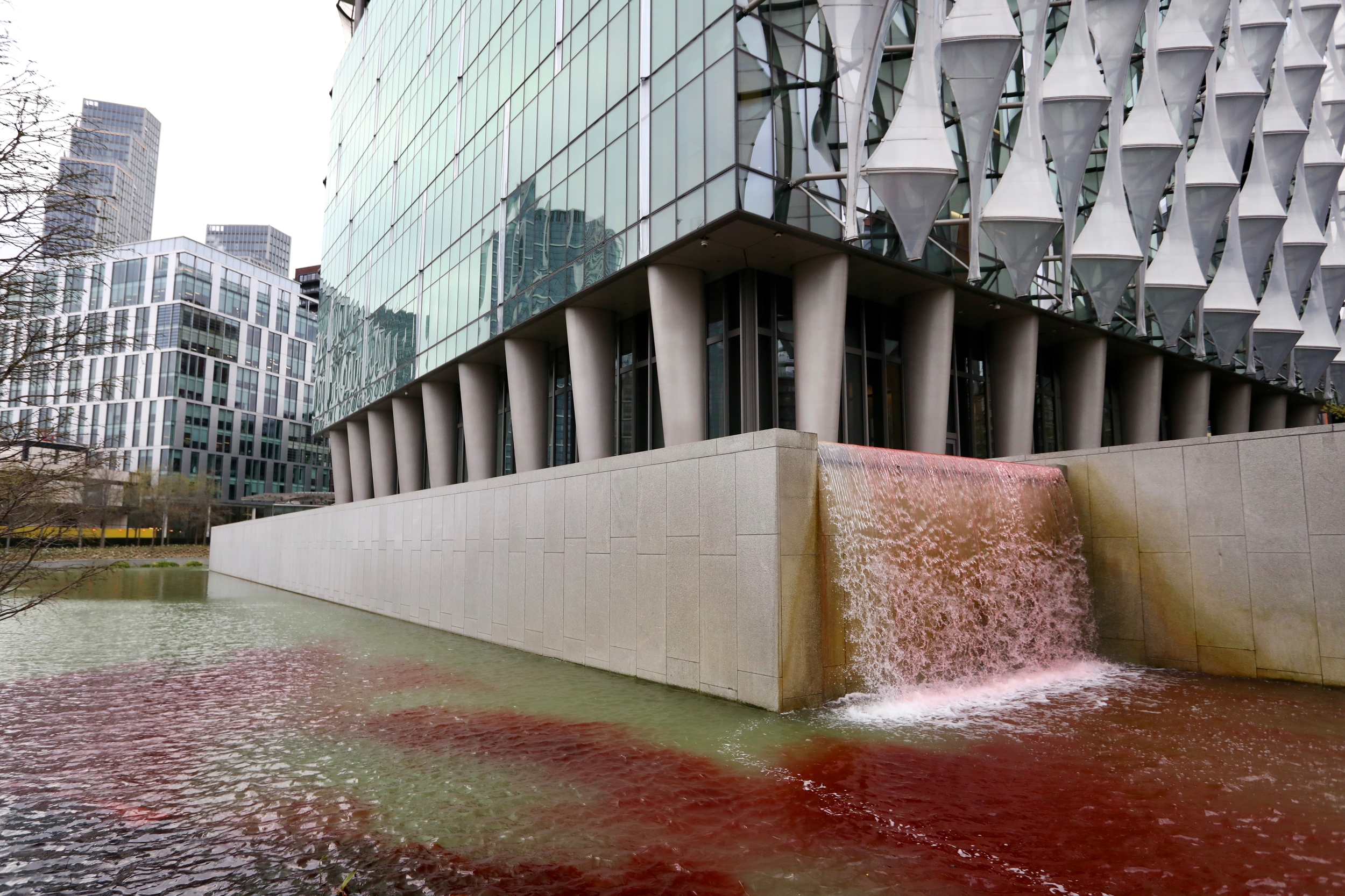 Blood-red dye stains an ornamental pond and waterfall outside the US Embassy in London.