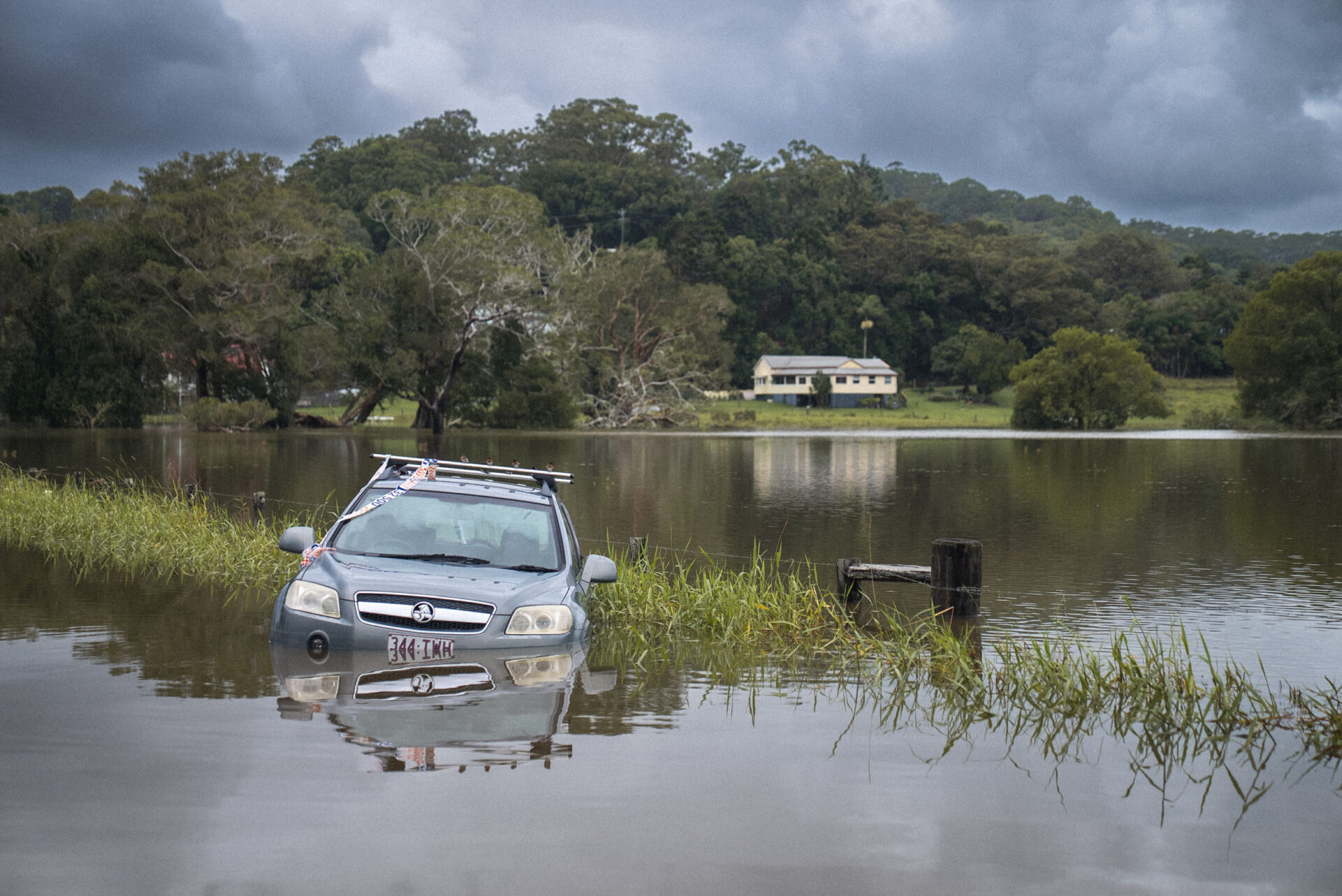A car is submerged in water after severe flooding.
