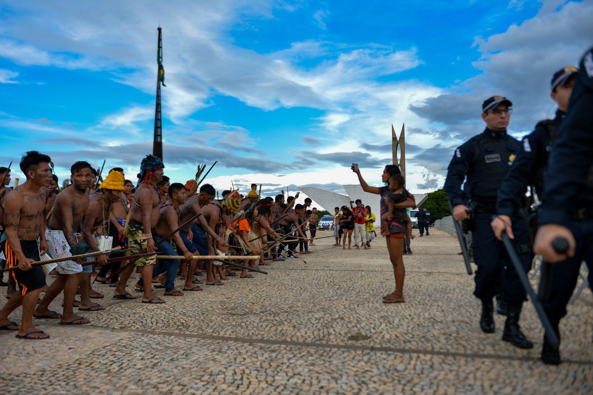 Indigenous People stand opposite police during the meeting with Minister Gilmar
