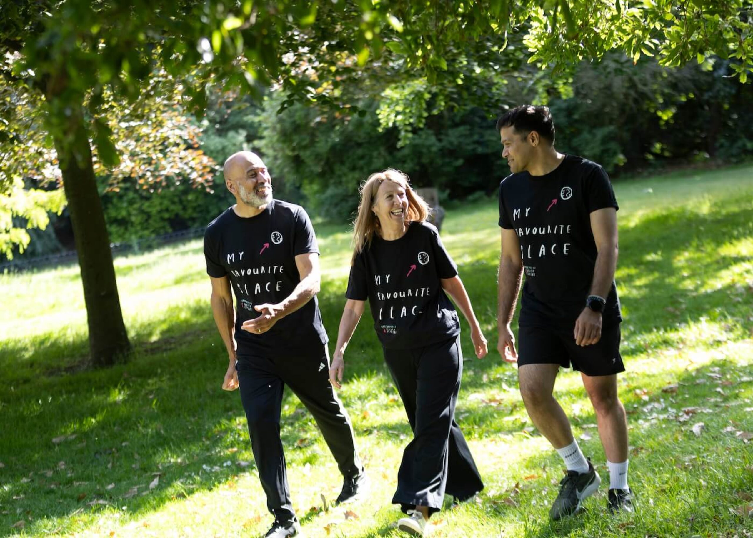 Happy people walking through grassy woodland