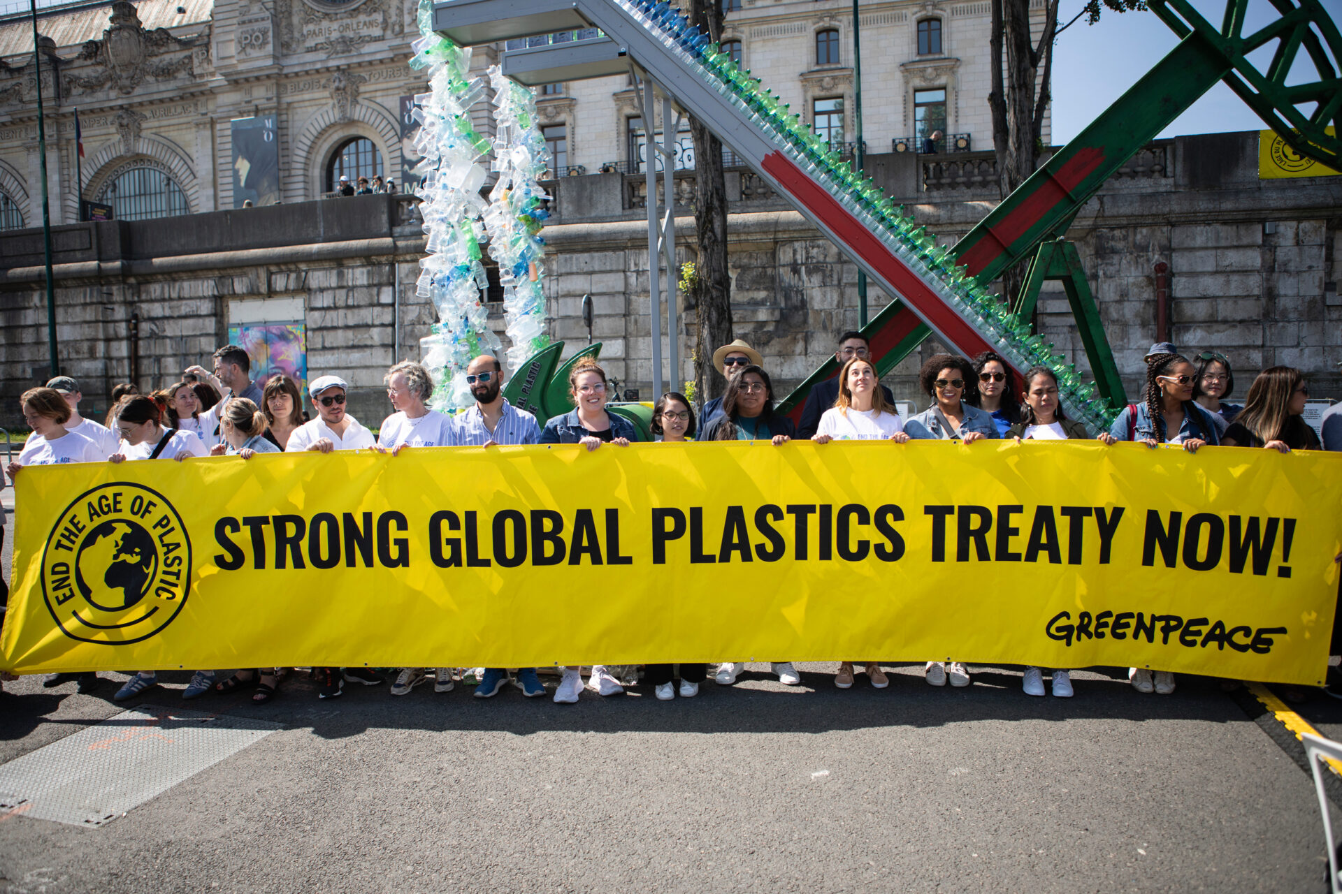 People standing with a banner reading 'Strong global plastics treaty now'