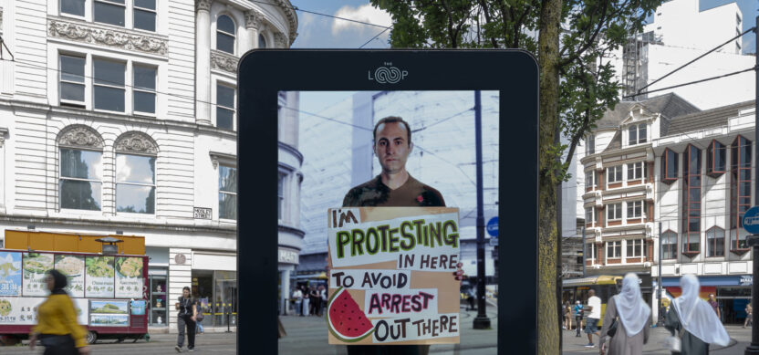 Man on a billboard with a sign saying I'm protesting in here to avoid arrest out there.