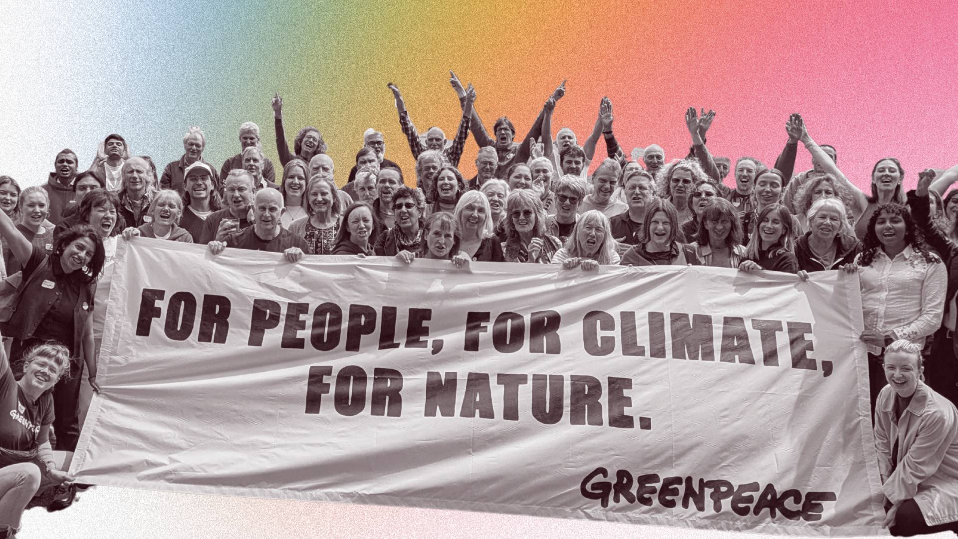 Smiling volunteers hold a for people, for nature, for climate banner